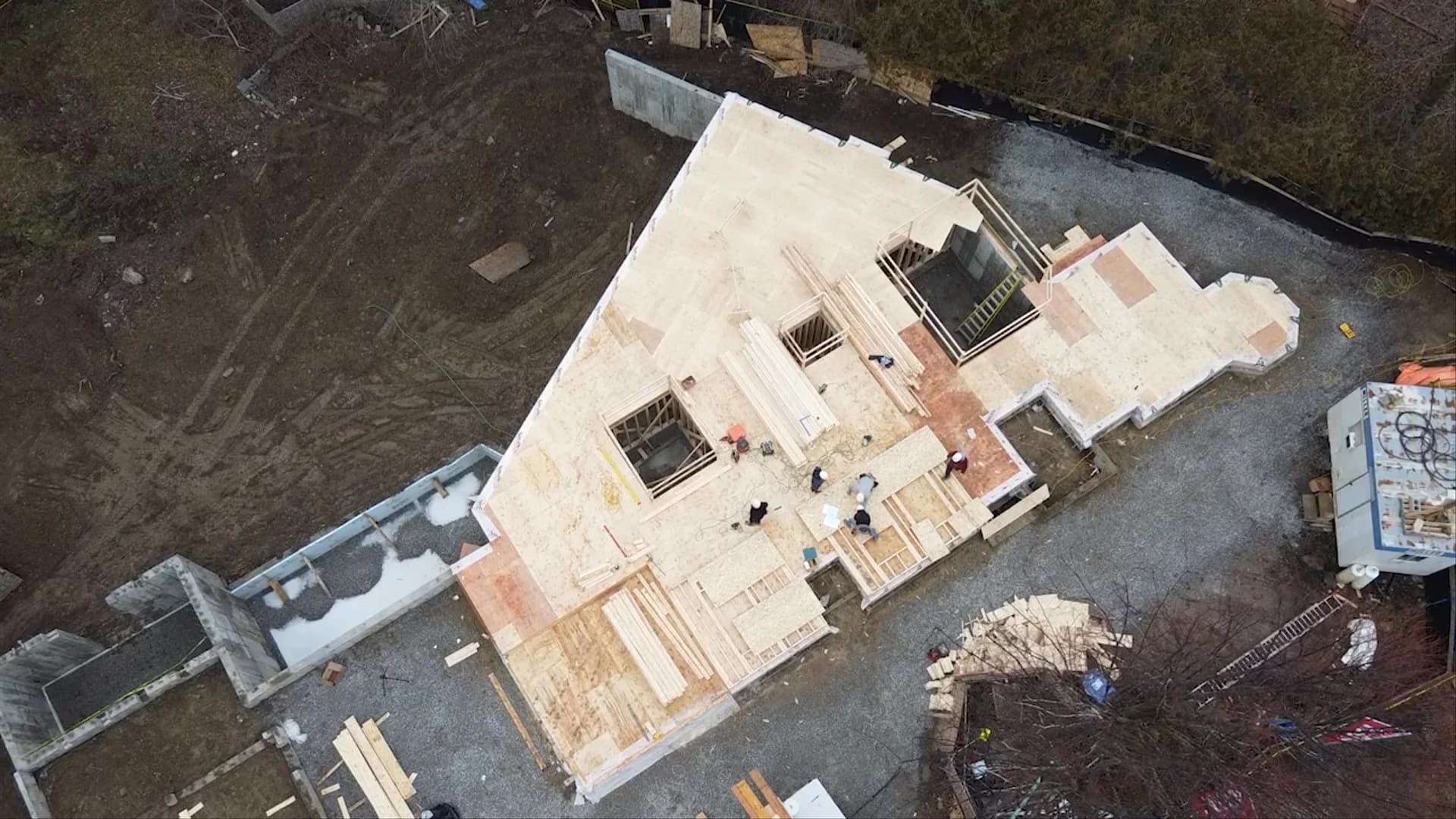Worker installing wood floor joists on a residential framing project