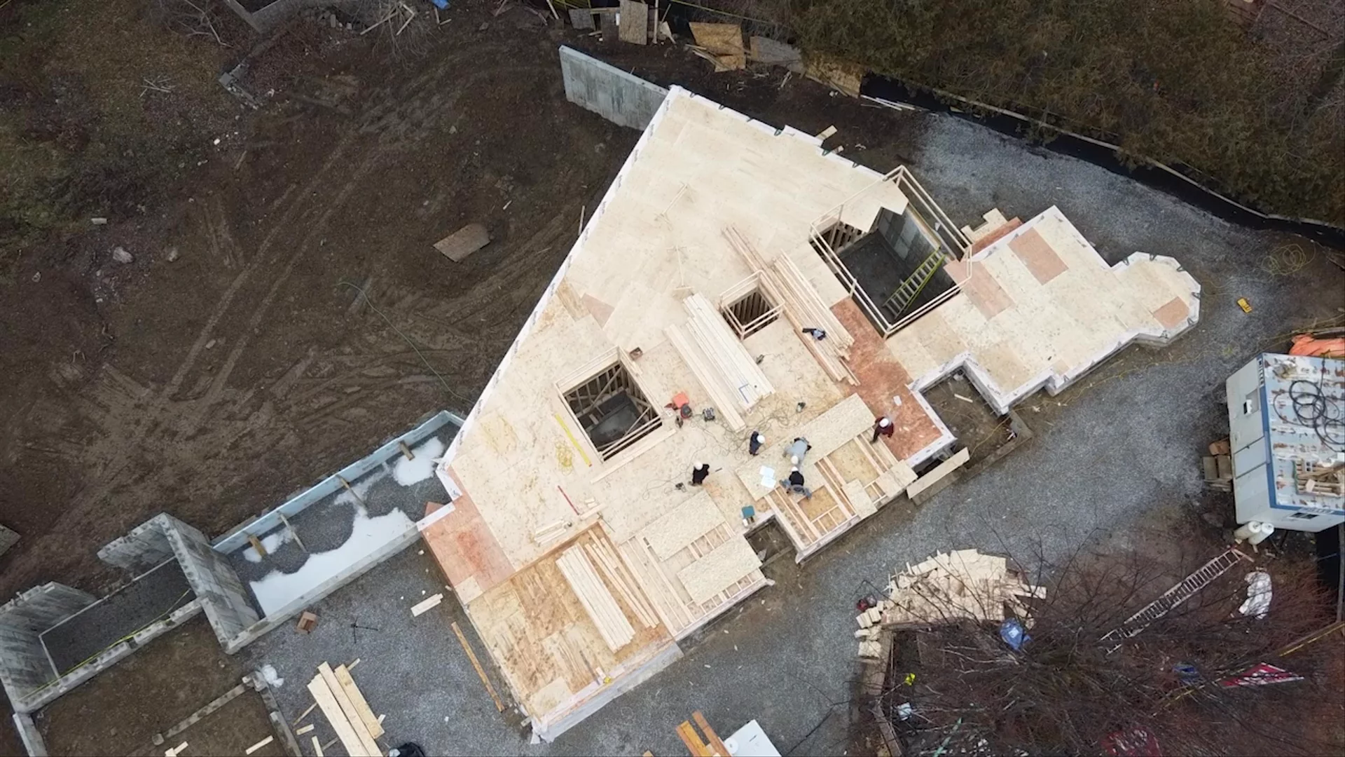 Worker installing wood floor joists on a residential framing project