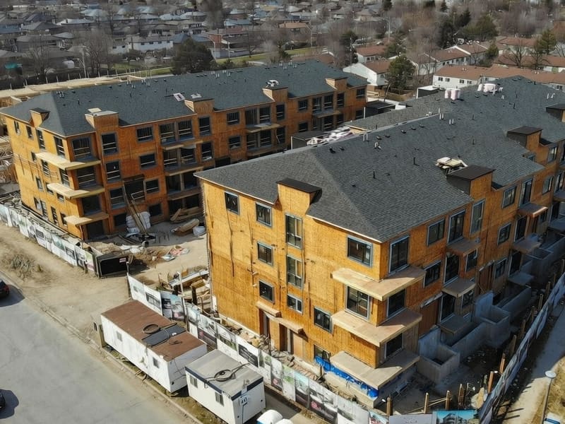 Aerial view of townhouse development under construction with wood framing and shingle roofs in Toronto